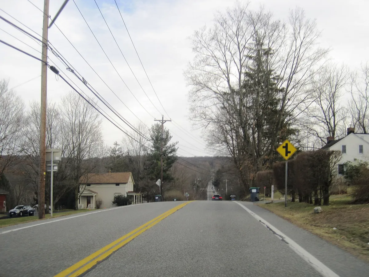 Route 17A passing houses and wooded hills in Bellvale, New York