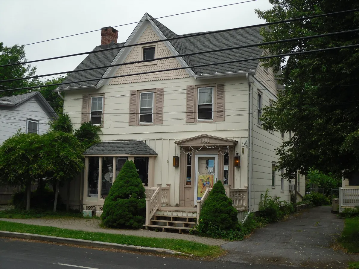 Older wood-sided house with a brick chimney in Sugar Loaf, New York